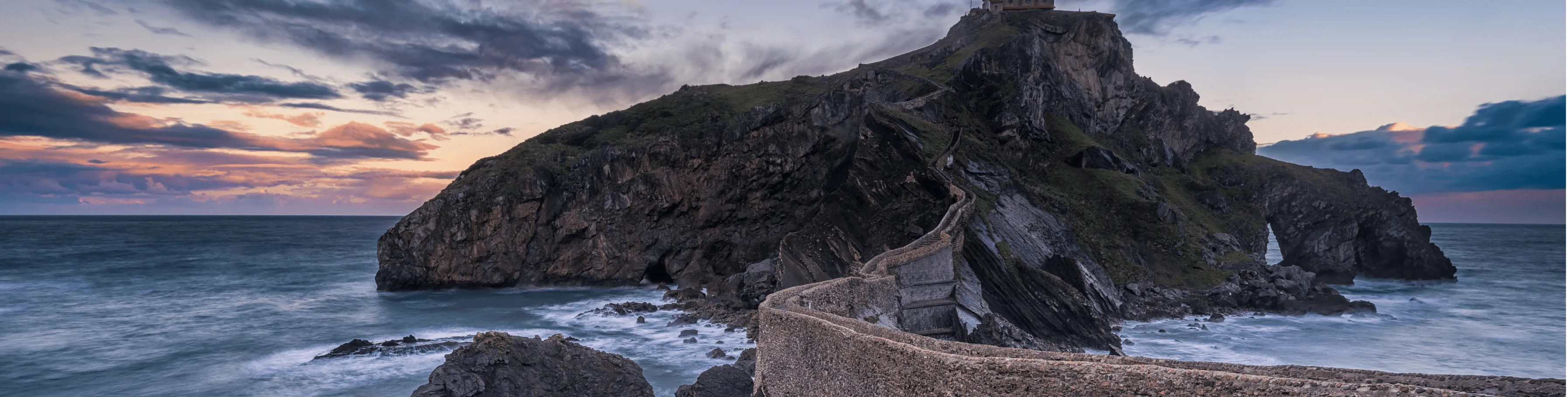 Vista del islote San Juan de Gaztelugatxe en el País Vasco, España, al atardecer - Banco Big.